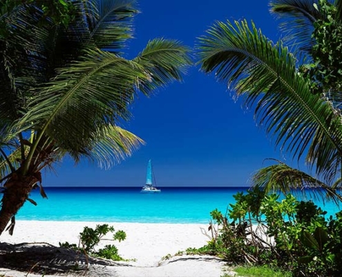 Anse-Georgette--with-sailboat-in-the-distance Anse-Georgette-with-sailboat-in-the-distance
