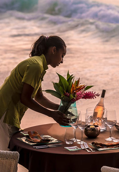 Seychelles Luxury Resorts, hero image, waitress serving dinner at a luxury resort