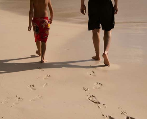 Anse Lazio, image shows tourists walking on the beach
